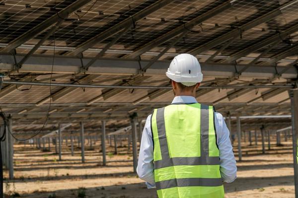 Solar technician in a safety vest on site