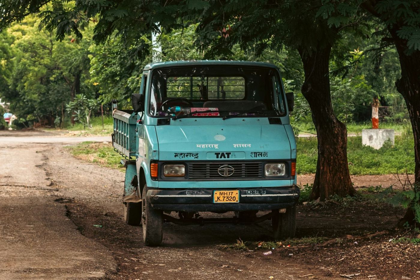 Flatbed K-truck parked under trees